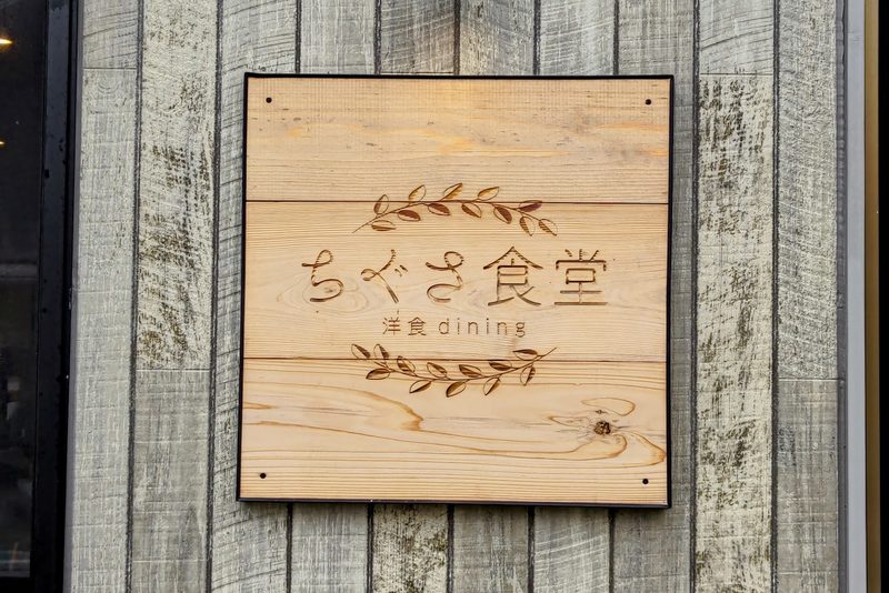 板張りの壁に掛けた「ちぐさ食堂 洋食dining」の木の看板